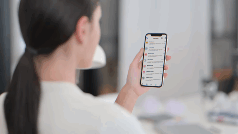 A woman looks at her smartphone screen displaying a list of health topics in one of the top period tracking apps